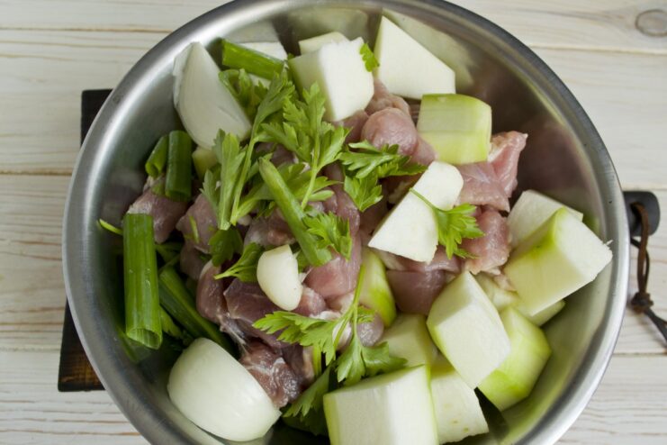 Grinding Meat and Vegetables for a Smooth Texture Meat and vegetables being processed in a food processor to create a smooth ground mixture.
