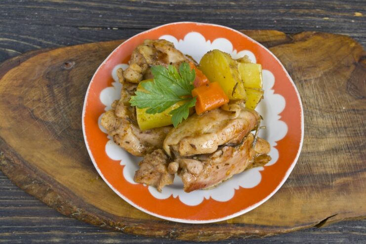 The Final Dish: Tender Oven-Baked Chicken with Potatoes The finished oven-baked chicken and potatoes served on a plate, garnished with parsley.