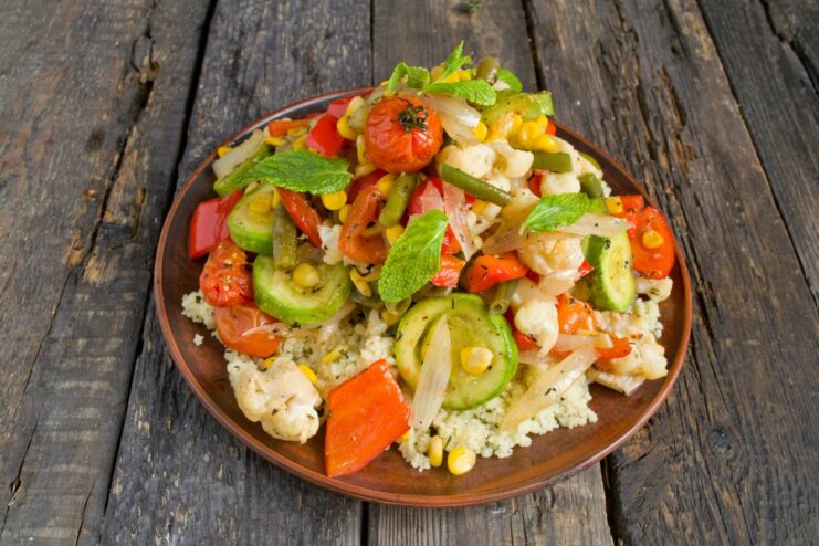 Finishing the dish with flavorful juices from the roasting pan. Drizzling the pan juices over a finished plate of roasted vegetables and couscous.