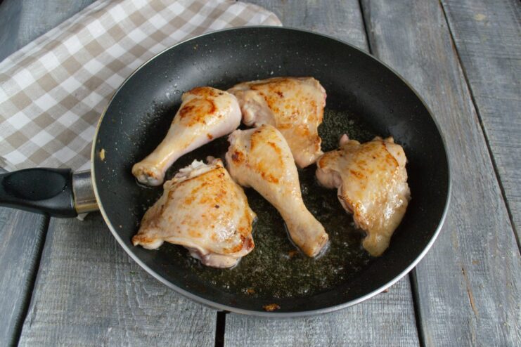 Frying Chicken Until Golden Brown for Maximum Flavor Chicken pieces frying in a pan until they are golden brown and crispy.