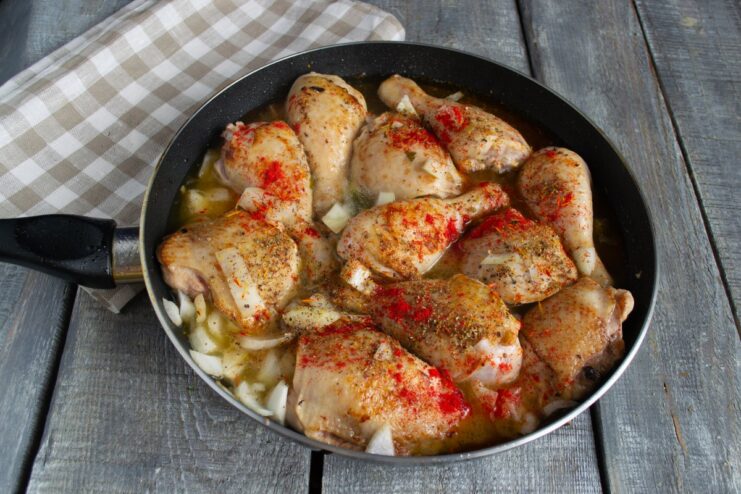 Simmering Chicken in Wine and Broth to Make it Tender Chicken simmering in a pan with wine and broth, creating a savory sauce.