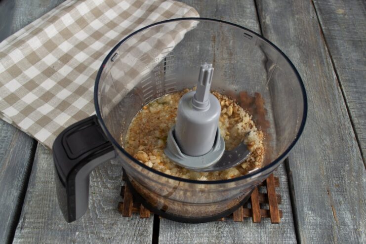 Blending the Nut Sauce Ingredients into a Smooth Purée Chicken broth being poured into a blender with peanuts, garlic, and bread before blending.