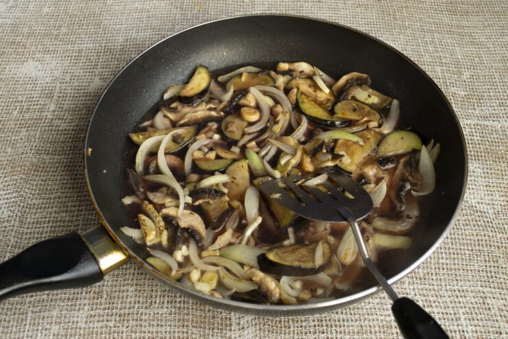Deglazing the pan with red wine to create a rich sauce Dry red wine being poured into the pan with vegetables to be reduced.