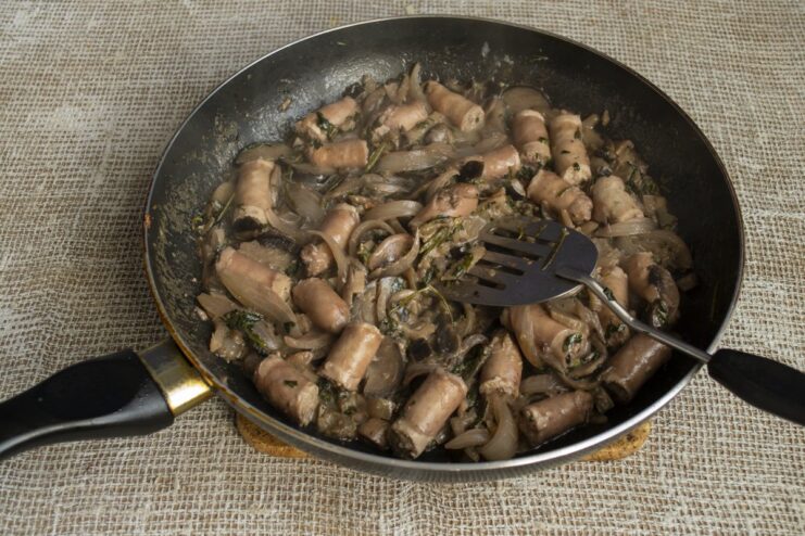 Final simmer to let all the flavors come together perfectly Chicken sausages simmering in the creamy mushroom and eggplant sauce in a pan.