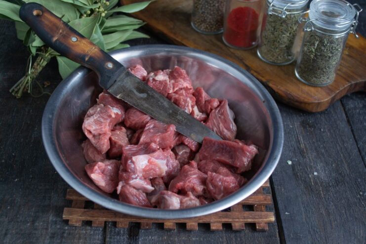 Cubing Beef for Plov Close-up of beef cubes on a cutting board, being prepared for the plov recipe.
