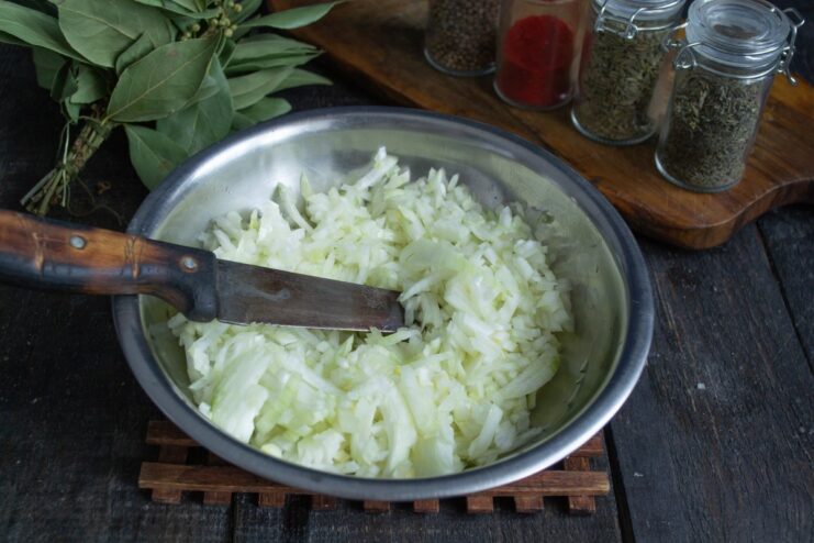 How to Finely Chop Onions for Plov A pile of finely chopped onions on a cutting board.