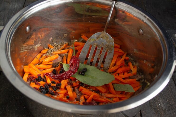 Creating the Flavorful Zirvak for Plov Spices, meat, and vegetables simmering in a pot to create the plov base (zirvak).