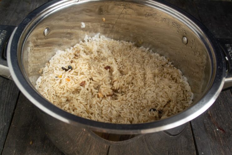 Simmering and Resting the Plov to Perfection A covered pot of plov simmering on the stove, ready for the final resting stage.
