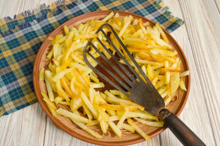A ring of golden fried potatoes arranged on a large white serving platter.