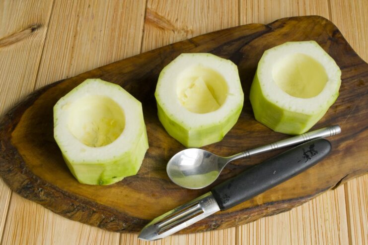 How to Core Zucchini for Stuffing Hollowed-out zucchini rounds on a cutting board, ready to be filled.