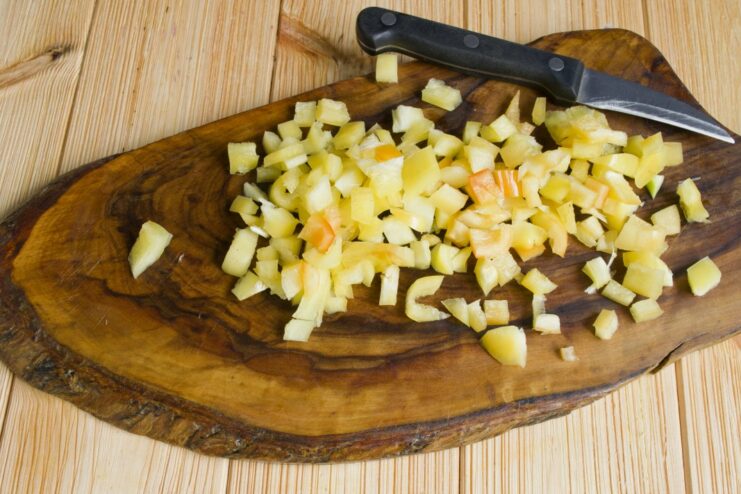 Cooking Bell Peppers with Onions and Carrots Diced bell peppers added to the pan with sautéed onions and carrots.
