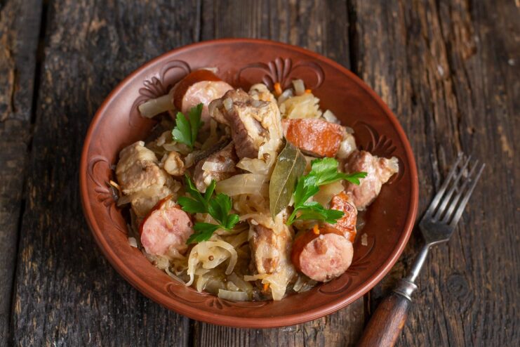 The finished Belarusian Bigos is ready to be served after resting. A spoonful of cooked Belarusian Bigos being lifted from the pot, ready to serve.