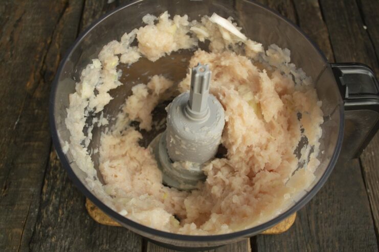 Preparing Ground Chicken for Meatballs Using a Blender Diced chicken fillet being processed into ground chicken inside a blender bowl.