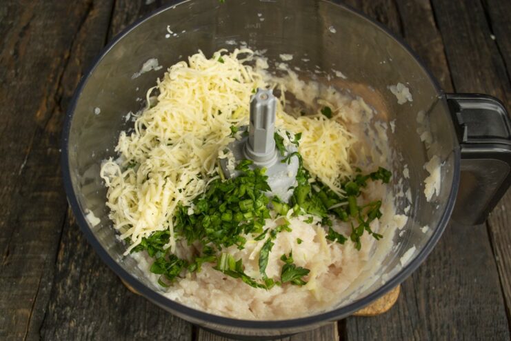 Incorporating Grated Parmesan for Extra Flavor Grated Parmesan cheese being added to the ground chicken and parsley mixture in a bowl.