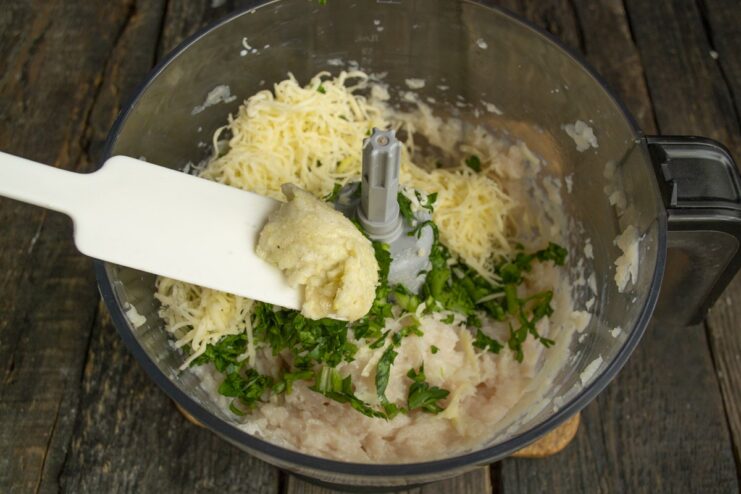Using Crushed Garlic to Enhance the Meatball Flavor A paste of crushed garlic and salt being added to the meatball mixture.