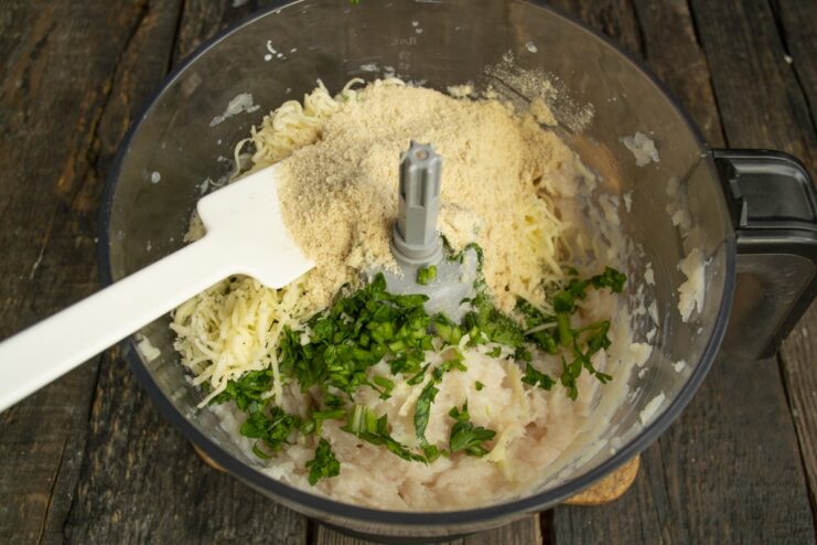 Adding Breadcrumbs as a Binder for the Meatballs Breadcrumbs being poured into the bowl with the chicken meatball mixture.