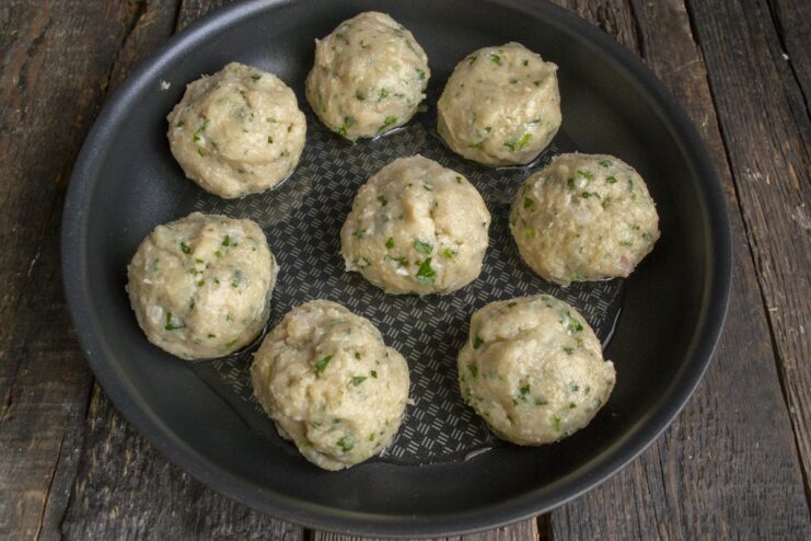 How to Form Perfectly Round Chicken Meatballs Hands forming a large, round meatball from the prepared chicken mixture.