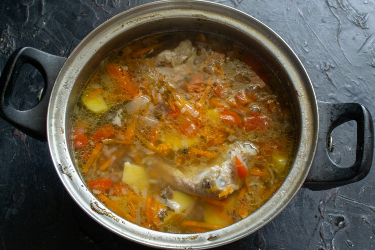 A pot of borscht with all the vegetables simmering on the stove.