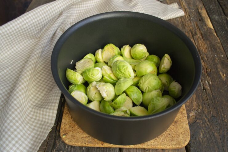 Blanching Brussels sprouts in salted boiling water. Halved Brussels sprouts in a pot with boiling water and salt.