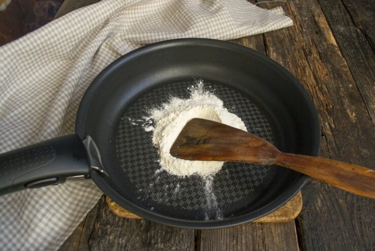 Making a roux by toasting flour in a dry skillet. Toasting all-purpose flour in a skillet until lightly golden.
