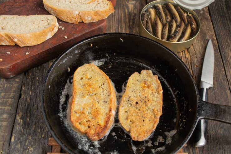 Frying the Bread until Golden Brown Egg-dipped bread slices frying to a golden brown in a pan.