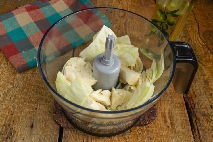 Finely Chopping Cabbage in a Blender - The 'Lazy' Method Chopped cabbage being placed into a blender bowl for the lazy golubtsy recipe.