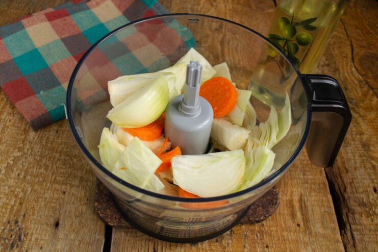 Adding Onion for a Flavorful Base Quartered onions added to the cabbage and carrots in the blender.