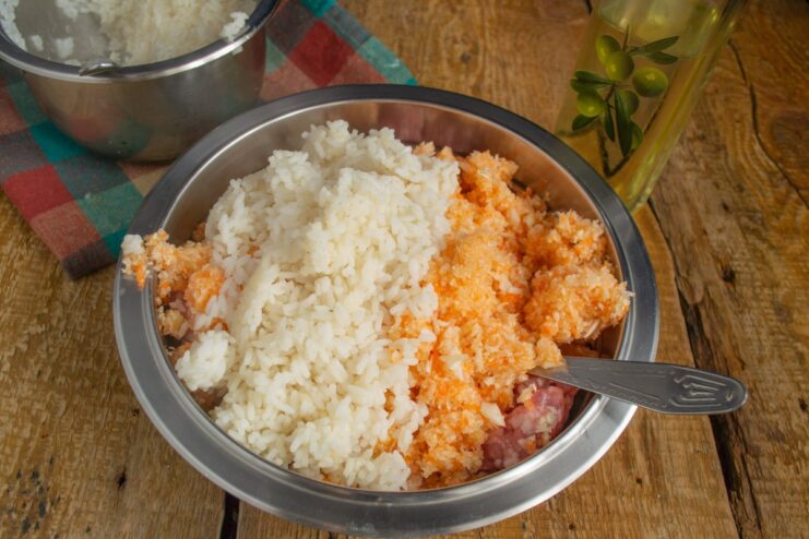 Combining Meat, Vegetables, and Rice for the Golubtsy Mixture Ground meat in a bowl with chopped vegetables and cooked rice on top, ready to be mixed.