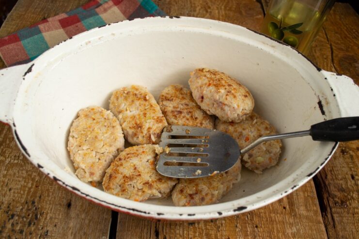 Browning the Rolls to Lock in Flavor Pan-frying oval-shaped lazy golubtsy until golden brown before stewing.