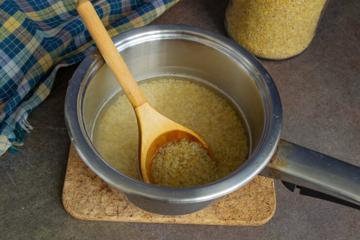 Cooking bulgur: bringing it to a boil in a pot A pot of bulgur and water starting to boil on the stove.