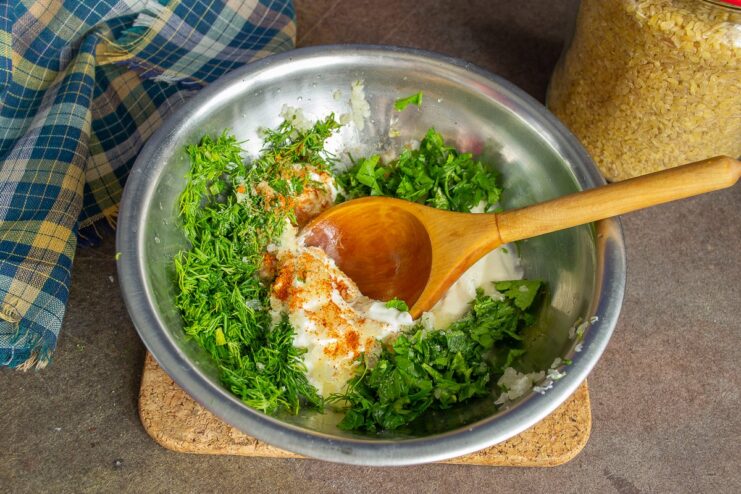 Preparing the creamy herb sauce for the pumpkin A bowl of smetana (sour cream) mixed with chopped dill, parsley, and spices.
