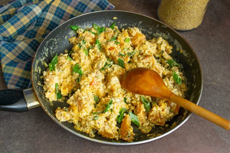 Final steps: combining all ingredients and garnishing The final dish of bulgur and pumpkin being mixed in the skillet, topped with green onions.