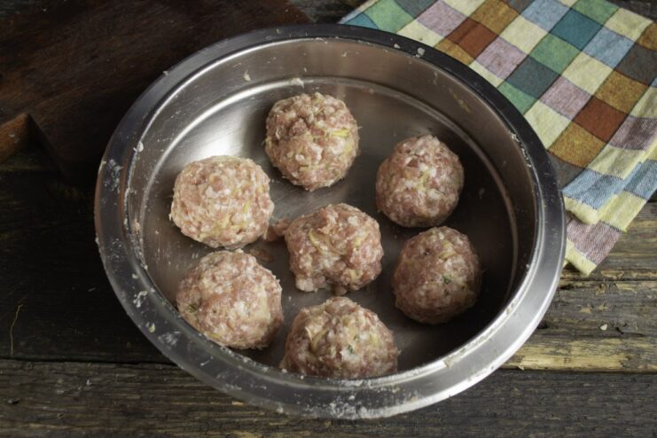 How to Form Perfectly Round Meat Patties Hands shaping the seasoned ground meat mixture into small, round patties.