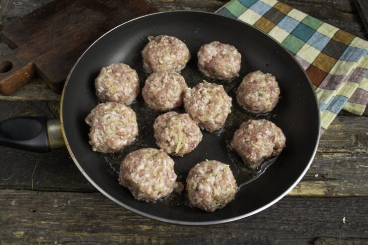 Searing Meat Patties to a Perfect Golden-Brown Crust Meat patties sizzling in a hot skillet, getting a golden-brown crust on one side.