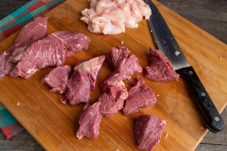 Dicing the Beef for the Filling Cubes of raw beef on a cutting board, ready for mincing.