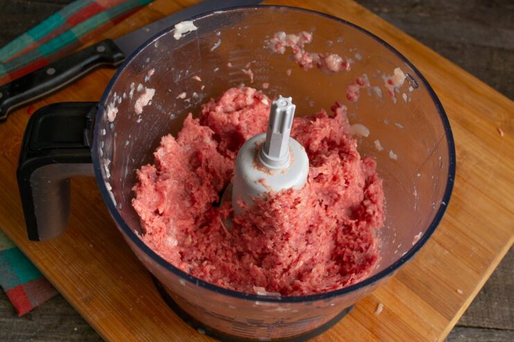 Mincing the Meat in a Blender A blender bowl filled with diced beef and chicken being processed into mince.