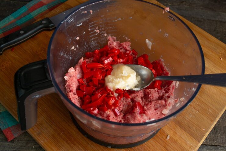 Adding Flavorings to the Meat Filling Meat mince in a bowl with added sautéed bell peppers and horseradish.