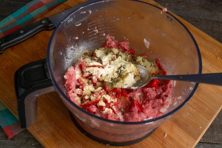 Seasoning the Filling and Adding Gelatin Adding spices and liquid gelatin to the beef and chicken mince mixture.