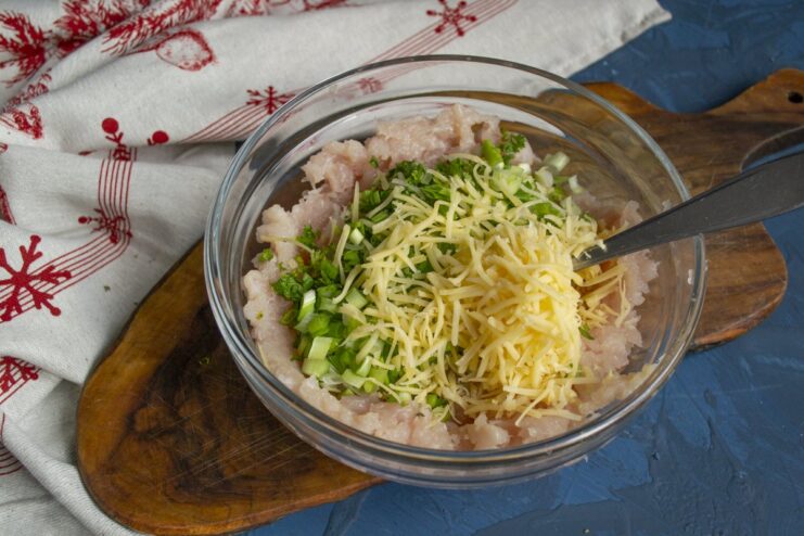 Adding Grated Parmesan for Flavor A block of Parmesan cheese being finely grated into the meat mixture.