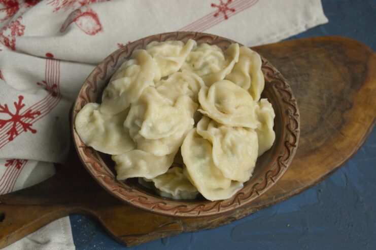 Cooking the Pelmeni Until Tender Homemade pelmeni boiling in a pot of water until they float to the surface.