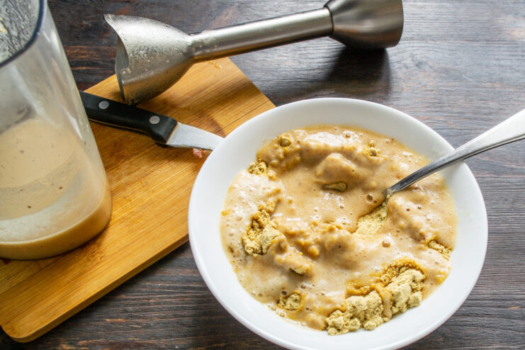Combining Liquid and Dry Ingredients for the Mustard Pouring the blended date mixture into the bowl with mustard powder.