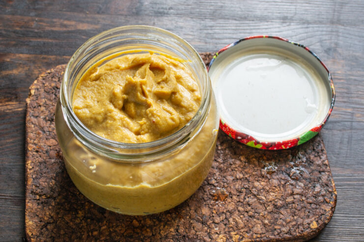 Storing the Homemade Mustard to Develop Flavor Transferring the finished homemade mustard into a clean glass jar for storage.