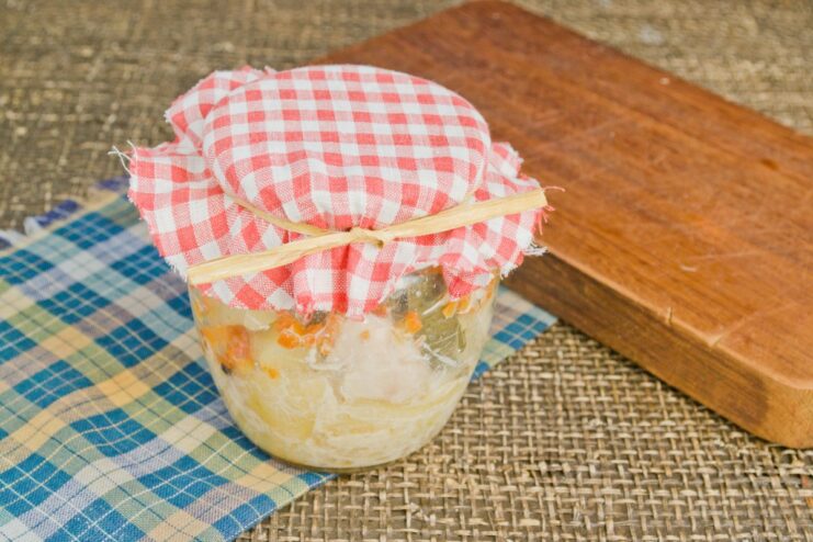 Storing Your Homemade Meal: Cooled Jars of Chicken and Potatoes Sealed jars of homemade chicken and potatoes ready for storage in a cool place.