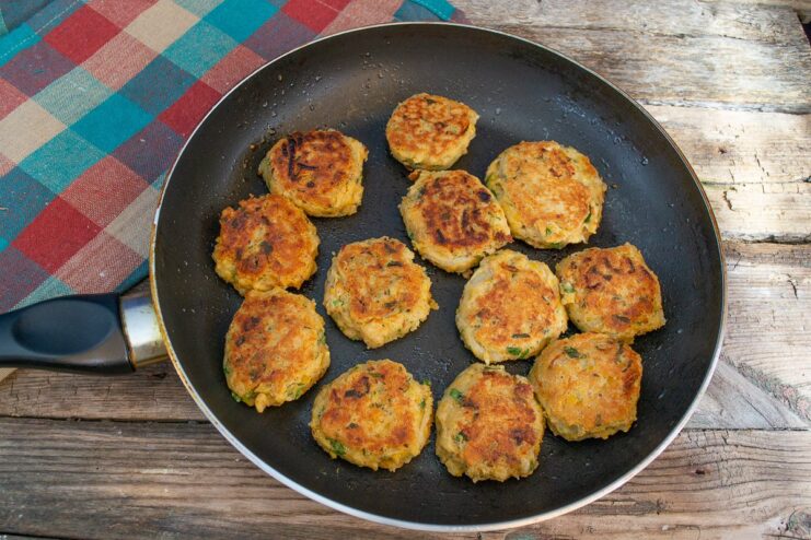 Golden-brown, freshly fried falafel resting on a plate lined with paper towels to drain excess oil.