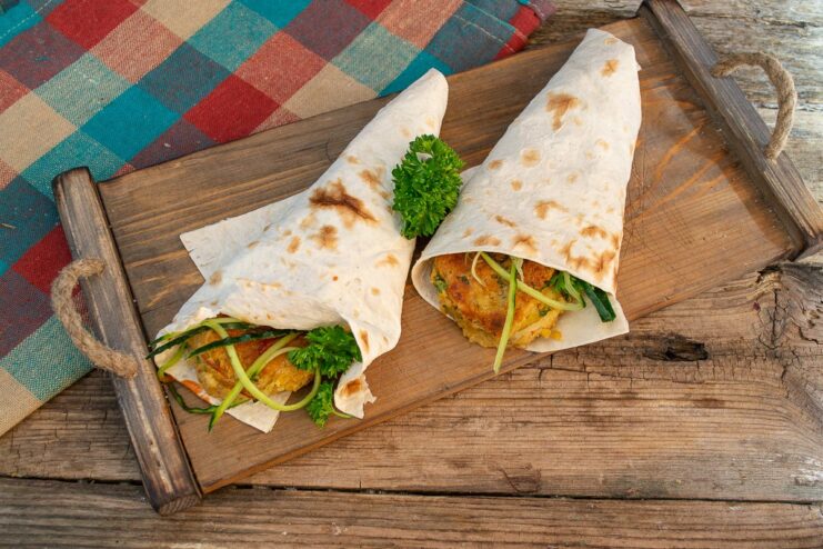 A finished falafel wrap, rolled into a cone shape and ready to be served and eaten.
