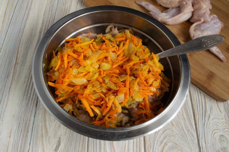 Mixing in sautéed onions and carrots to complete the stuffing Sautéed onions and carrots being added to the chicken and mushroom mince.