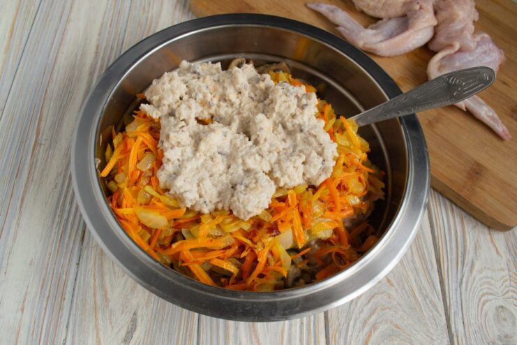 Final step for the stuffing: adding cream-soaked bread for moisture Mixing all stuffing ingredients, including bread, in a bowl.