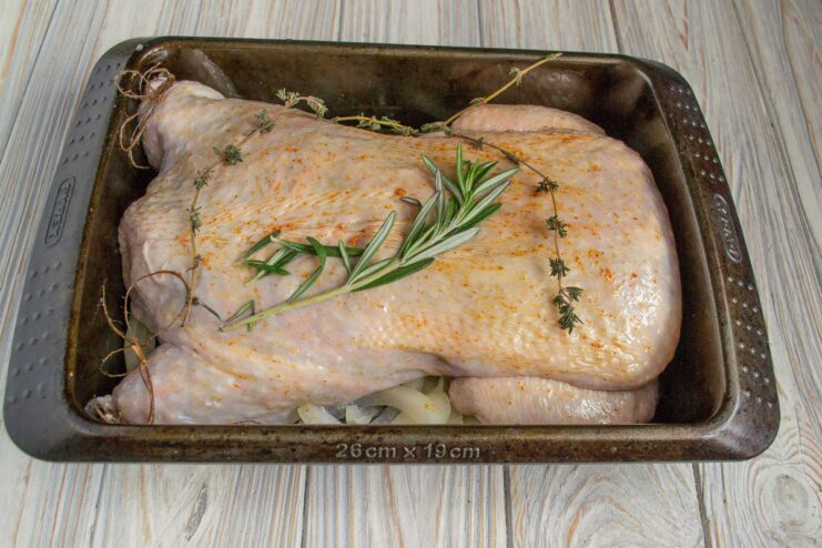 Seasoning the chicken before it goes into the oven The stuffed raw chicken in a baking dish, seasoned with paprika and herbs.