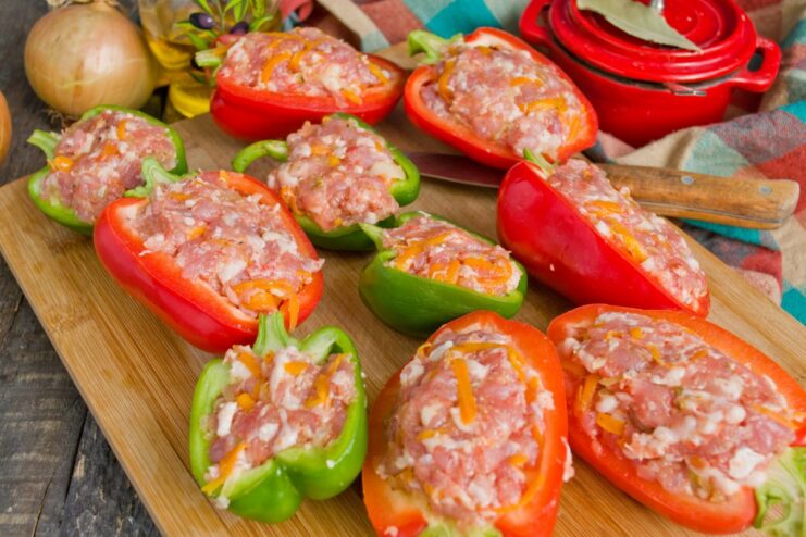 Stuffing the Bell Pepper Halves with Meat Filling Bell pepper halves being generously filled with the prepared minced meat and vegetable mixture.
