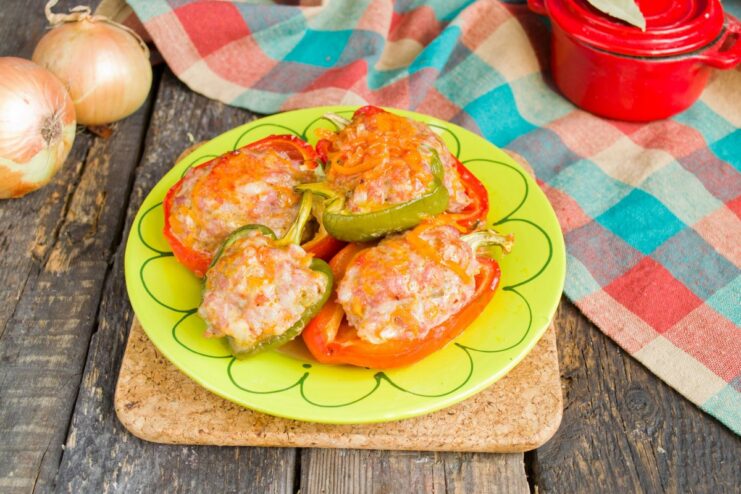 Serving Hot and Freshly Baked Stuffed Peppers A serving of hot, baked stuffed peppers on a plate, garnished with fresh herbs and a dollop of sour cream.